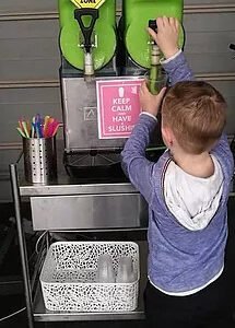 Boy pouring drink from slushie machine