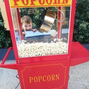 boy looking at popcorn in popcorn machine